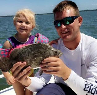 Hallie Kate and Captain Jared with a baby flounder Hallie Kate and Captain Jared with a baby flounder